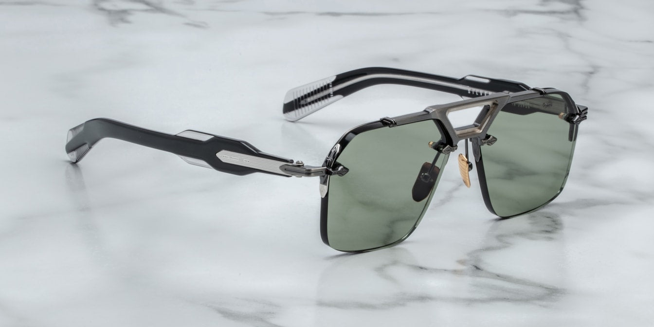 A pair of rimless sunglasses with a gunmetal frame, titanium nose-and-brow bridge, dual-tone details, sculptural acetate temples, and wirecore embellishments. side view