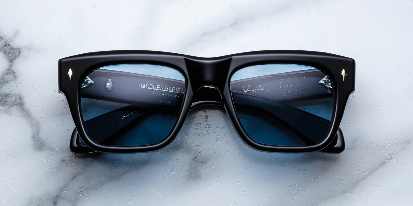 Black sunglasses with blue lenses on a marble surface