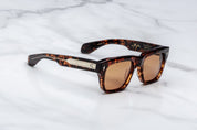 Sunglasses with tortoiseshell frame and brown lenses on a marble surface