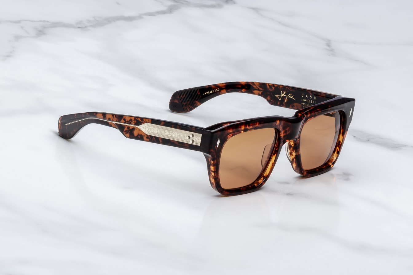 Sunglasses with tortoiseshell frame and brown lenses on a marble surface