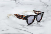 Dark tortise shell sunglass with sterling silver arrow head pin on the sides blue lenses and tortise shel temples
