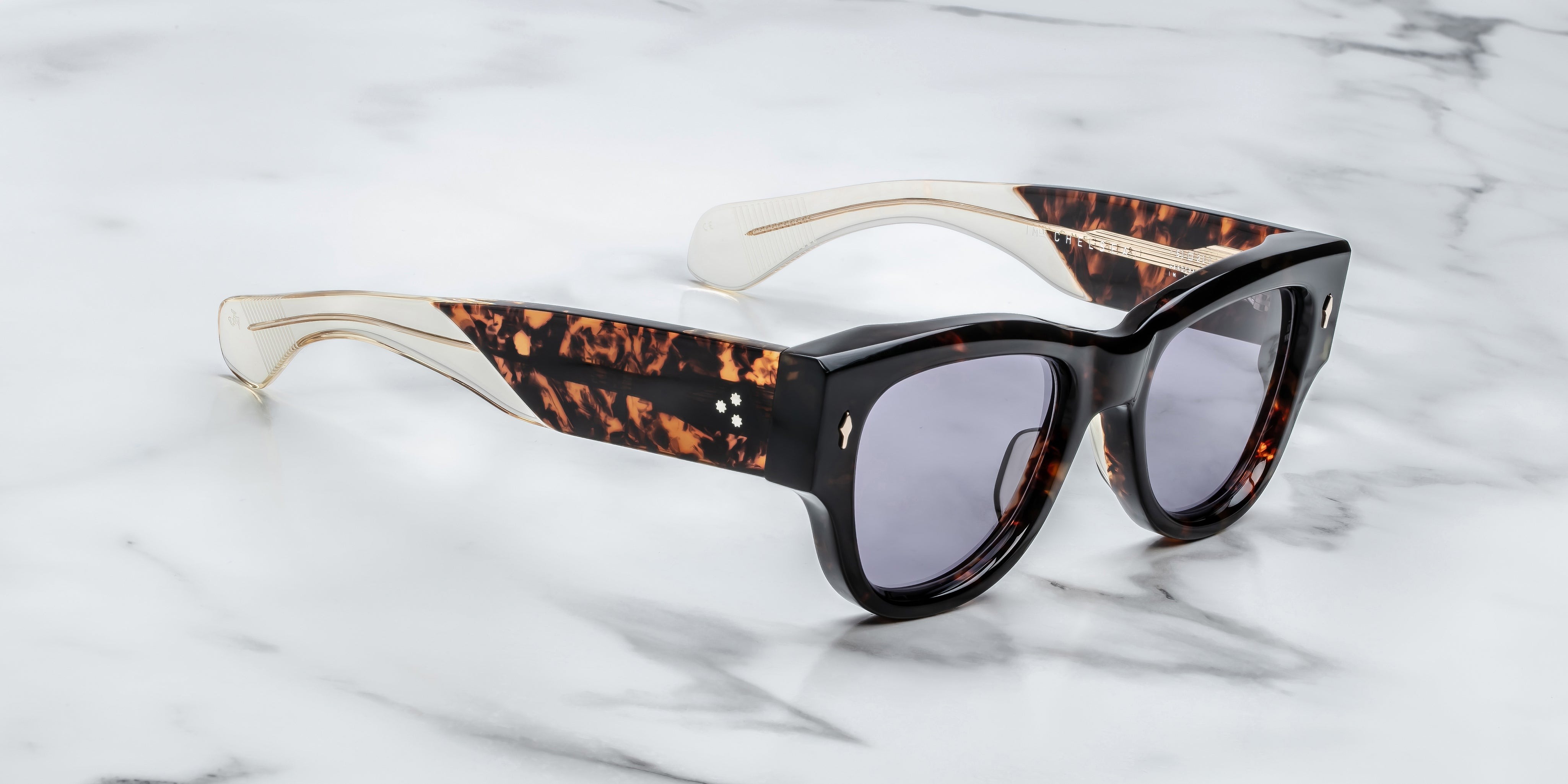Dark tortise shell sunglass with sterling silver arrow head pin on the sides blue lenses and tortise shel temples