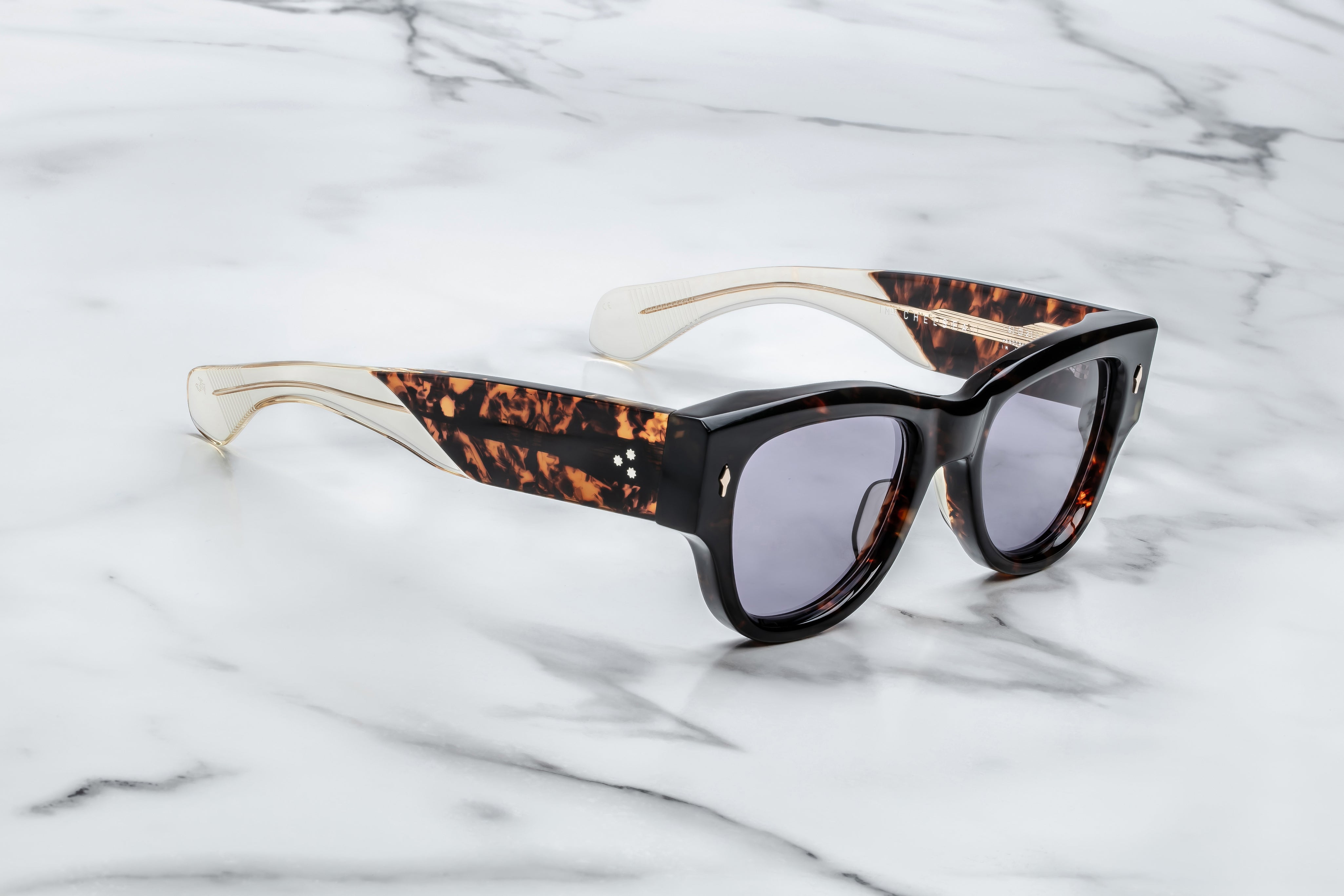 Dark tortise shell sunglass with sterling silver arrow head pin on the sides blue lenses and tortise shel temples