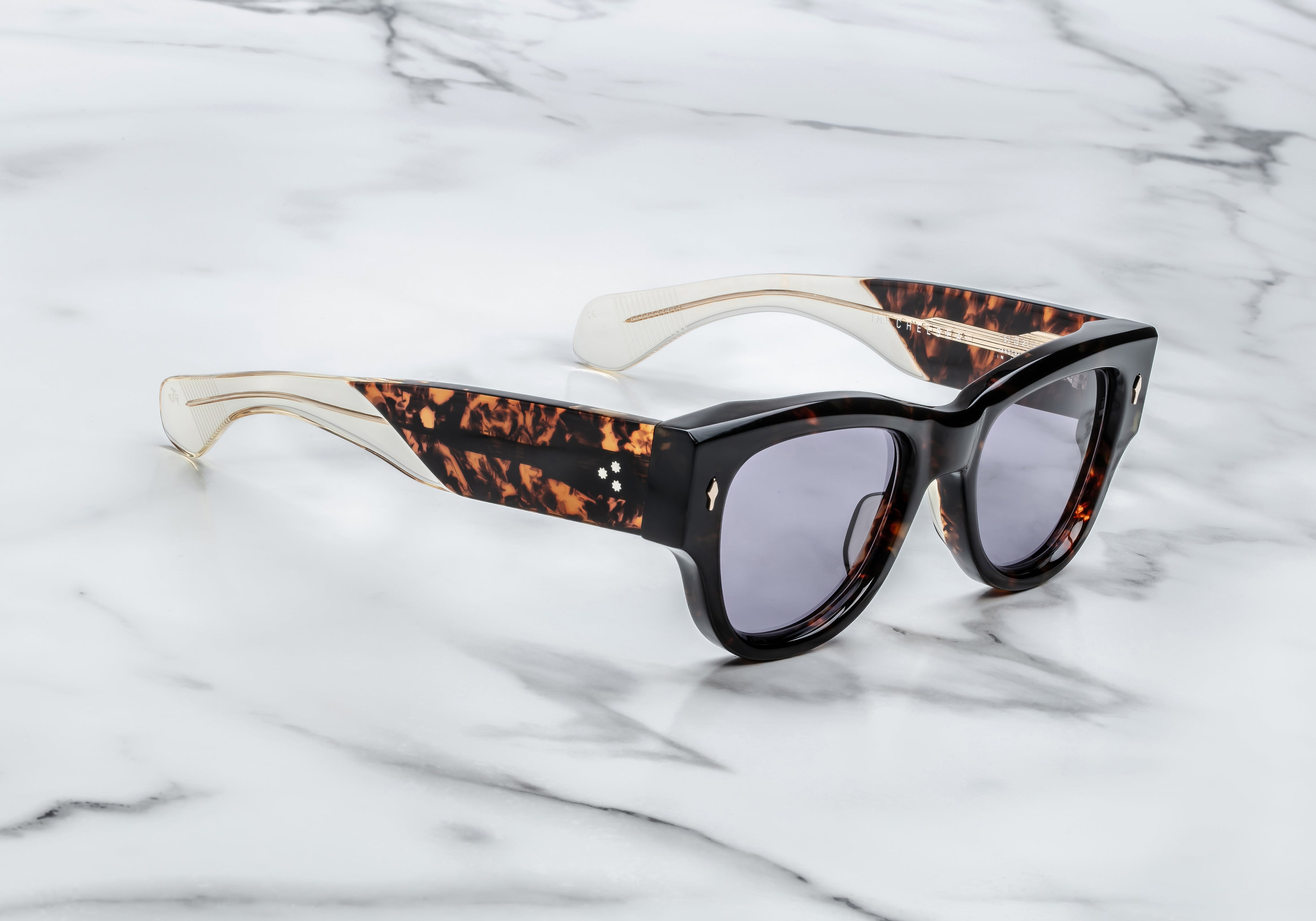 Dark tortise shell sunglass with sterling silver arrow head pin on the sides blue lenses and tortise shel temples