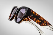 Dark tortise shell sunglass with sterling silver arrow head pin on the sides blue lenses and tortise shel temples