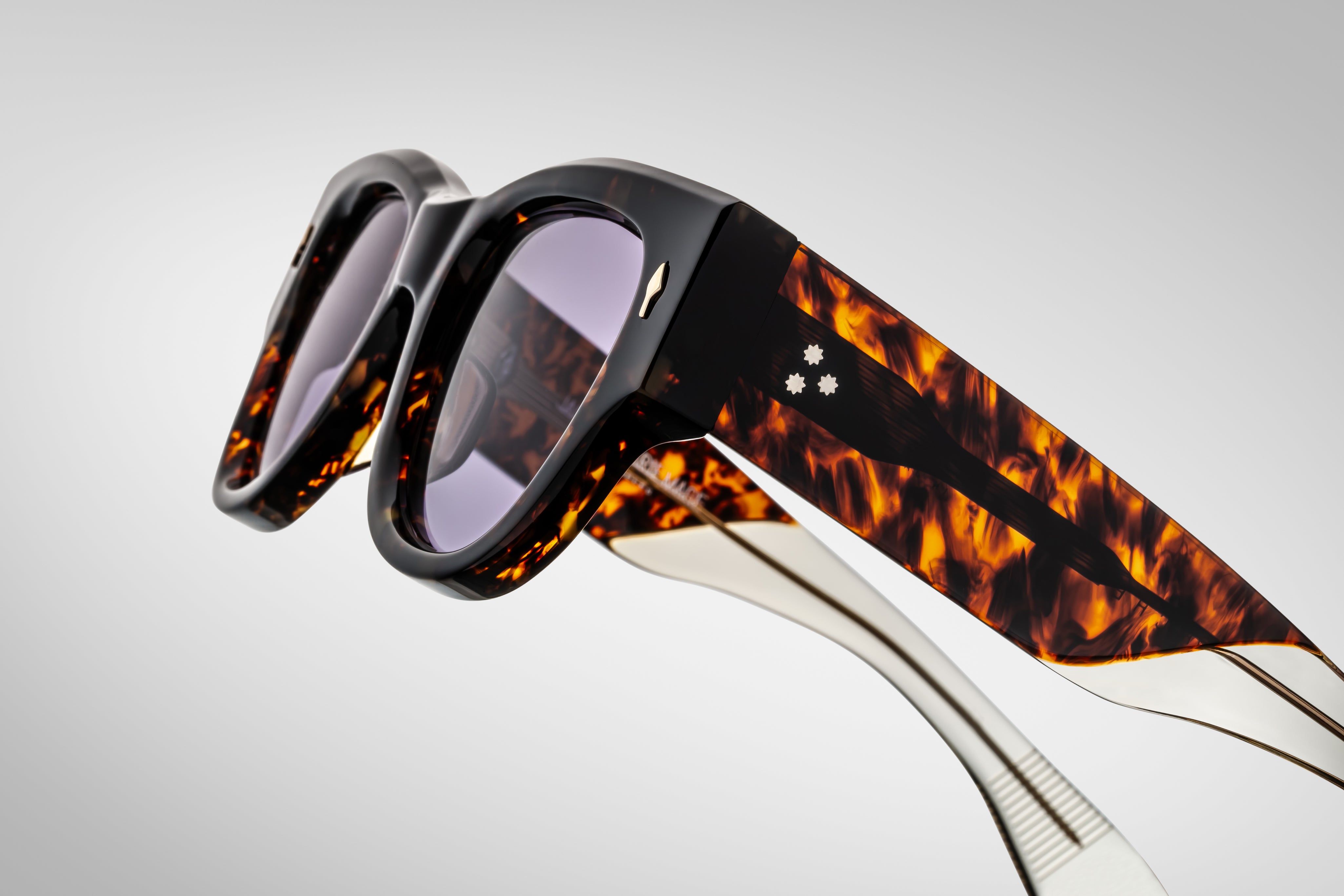 Dark tortise shell sunglass with sterling silver arrow head pin on the sides blue lenses and tortise shel temples