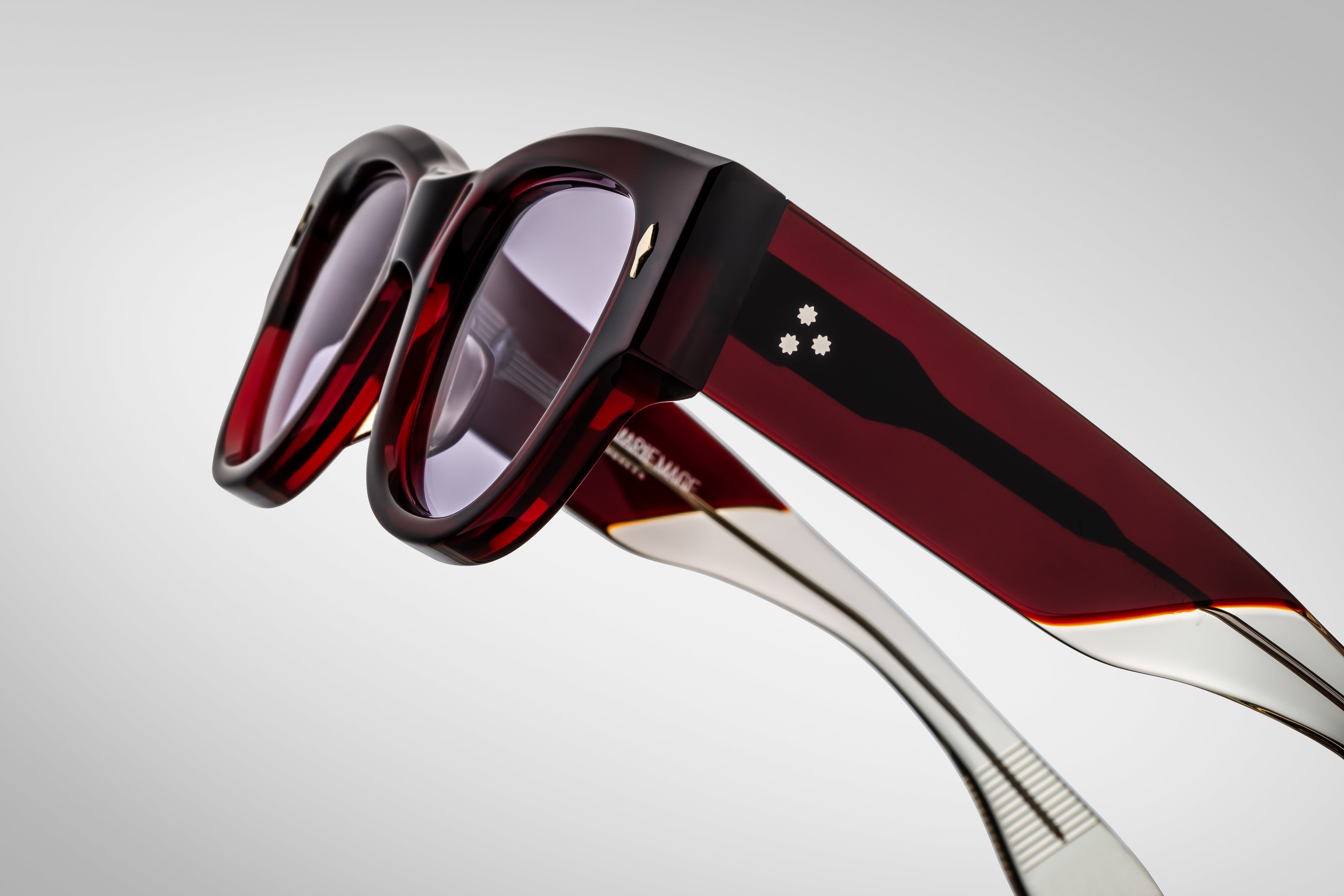 Deep red shell sunglass with sterling silver arrow head pin on the sides side view