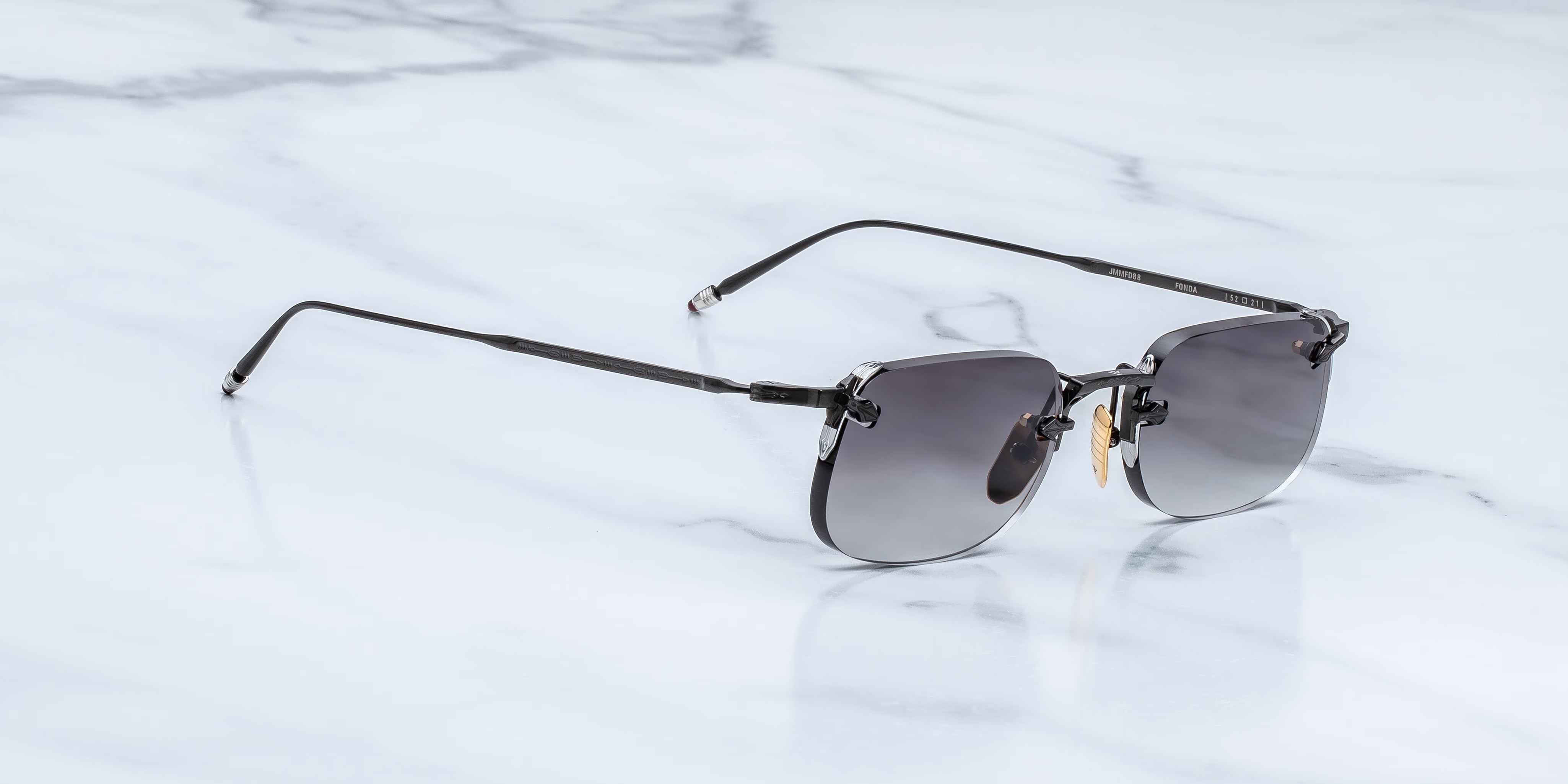 Slide view of rimless sunglass with black titanium temples