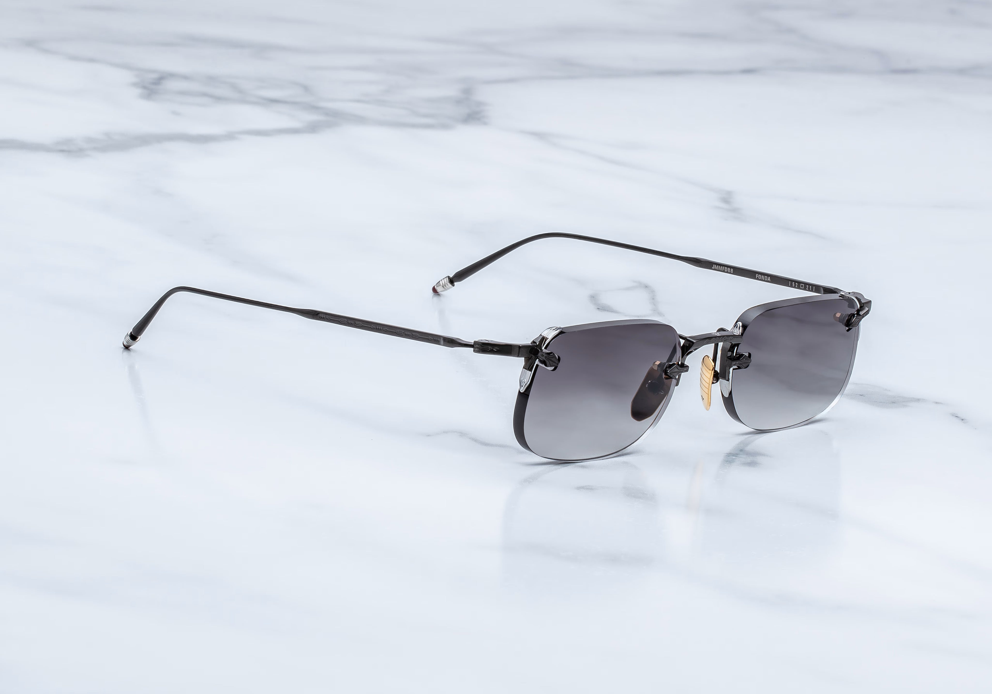 Slide view of rimless sunglass with black titanium temples