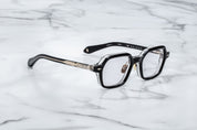 side view of JM holden frame black with clear acetate on the back and light gold detail on temples