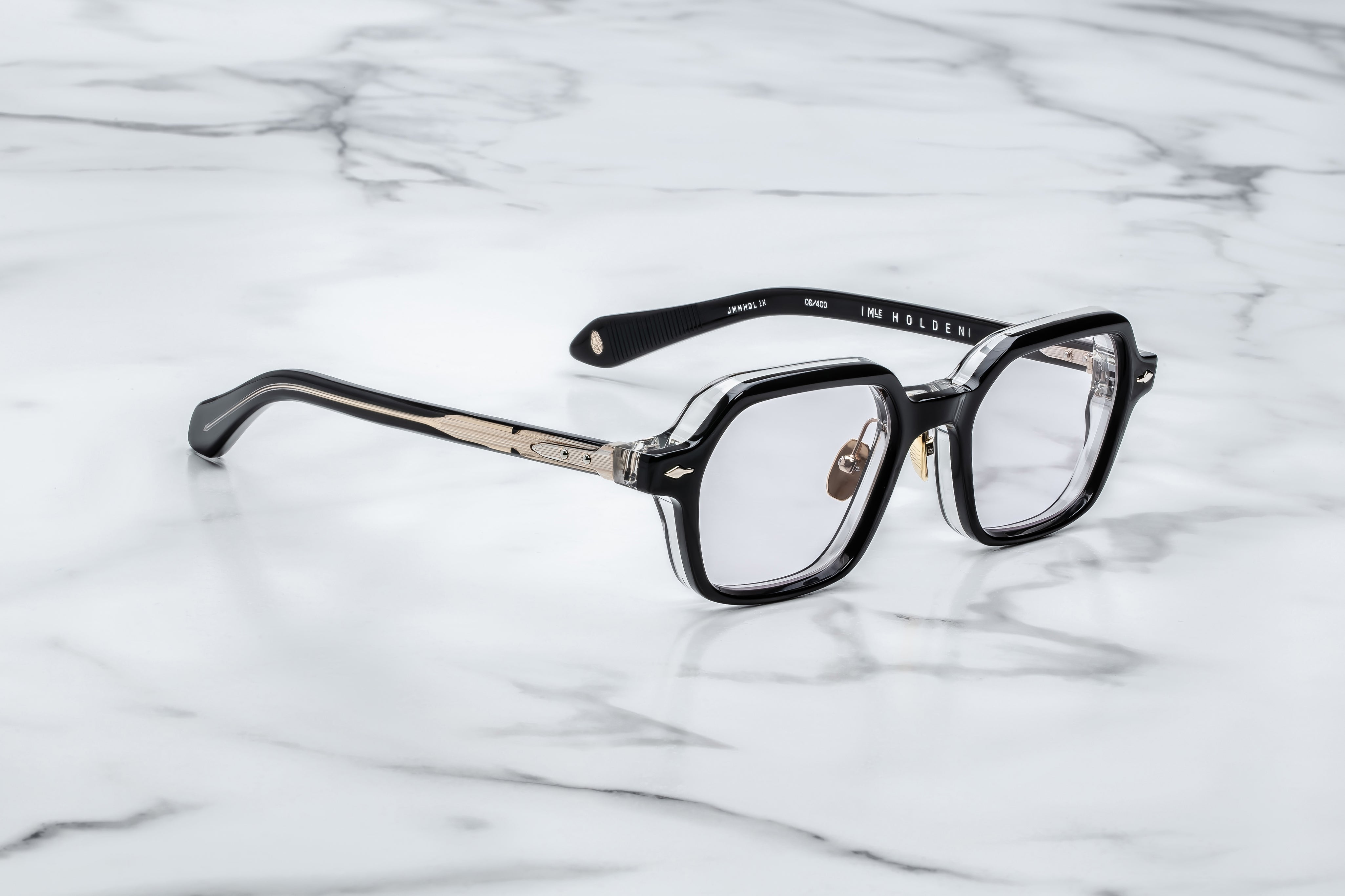 side view of JM holden frame black with clear acetate on the back and light gold detail on temples