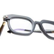 close up of a mat black square frame with gold temples