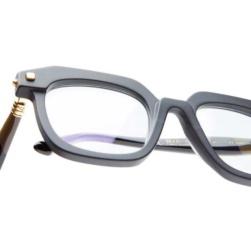 close up of a mat black square frame with gold temples