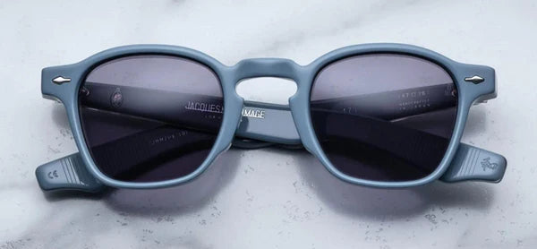 A pair of sunglasses with a distinctive frame, sculptural temples, and a sophisticated silhouette. The frame is notable for its slim lines.