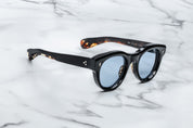 round sunglass in black with silver arrow pin motif on the sidesside view