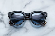 round sunglass in black with silver arrow pin motif on the sides