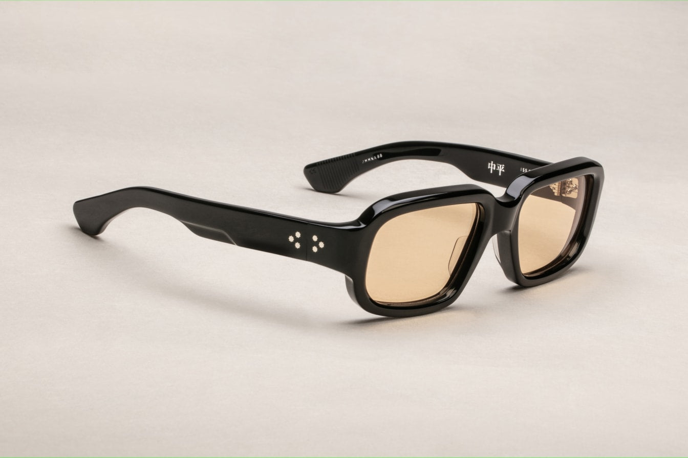 A pair of black rectangular eyeglasses with a modest wrap-around effect, featuring exposed wirecore temples. side view