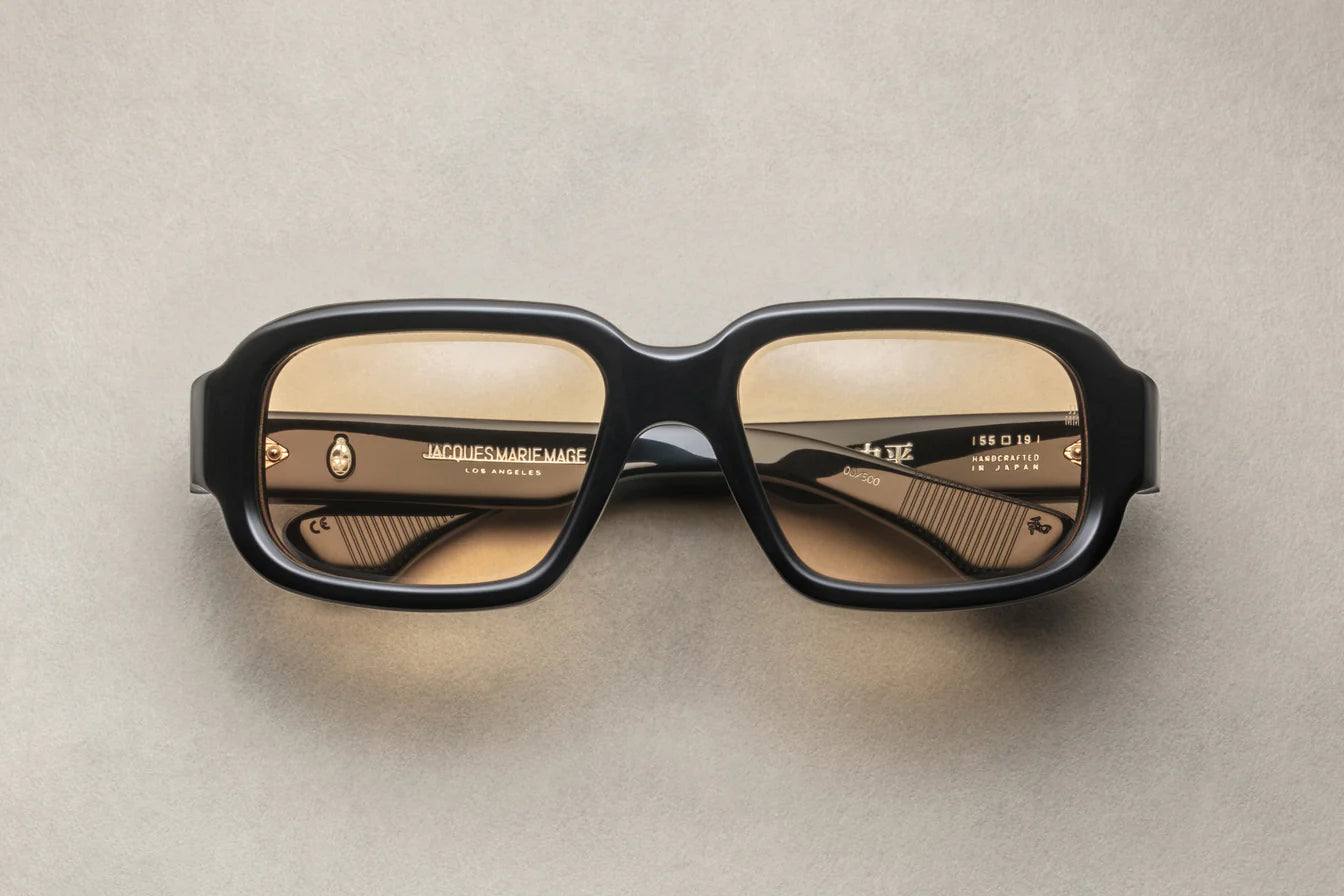 A pair of black rectangular eyeglasses with a modest wrap-around effect, featuring exposed wirecore temples.