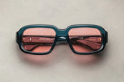 A pair of indigo rectangular eyeglasses with a modest wrap-around effect, featuring exposed wirecore temples.