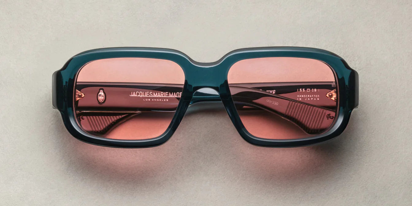 A pair of indigo rectangular eyeglasses with a modest wrap-around effect, featuring exposed wirecore temples.