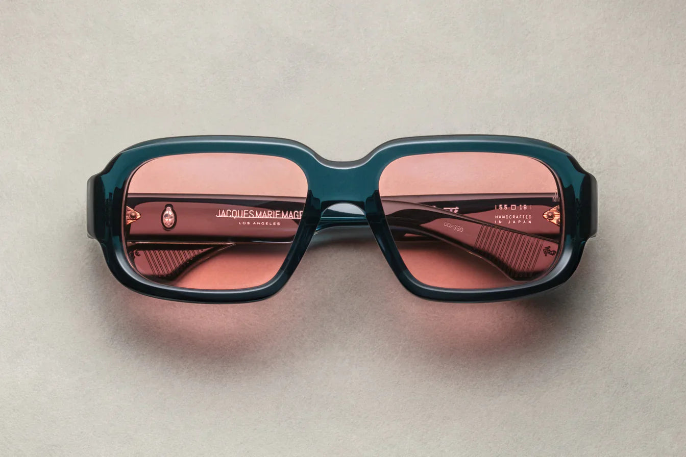 A pair of indigo rectangular eyeglasses with a modest wrap-around effect, featuring exposed wirecore temples.
