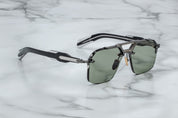 A pair of rimless sunglasses with a gunmetal frame, titanium nose-and-brow bridge, dual-tone details, sculptural acetate temples, and wirecore embellishments. side view