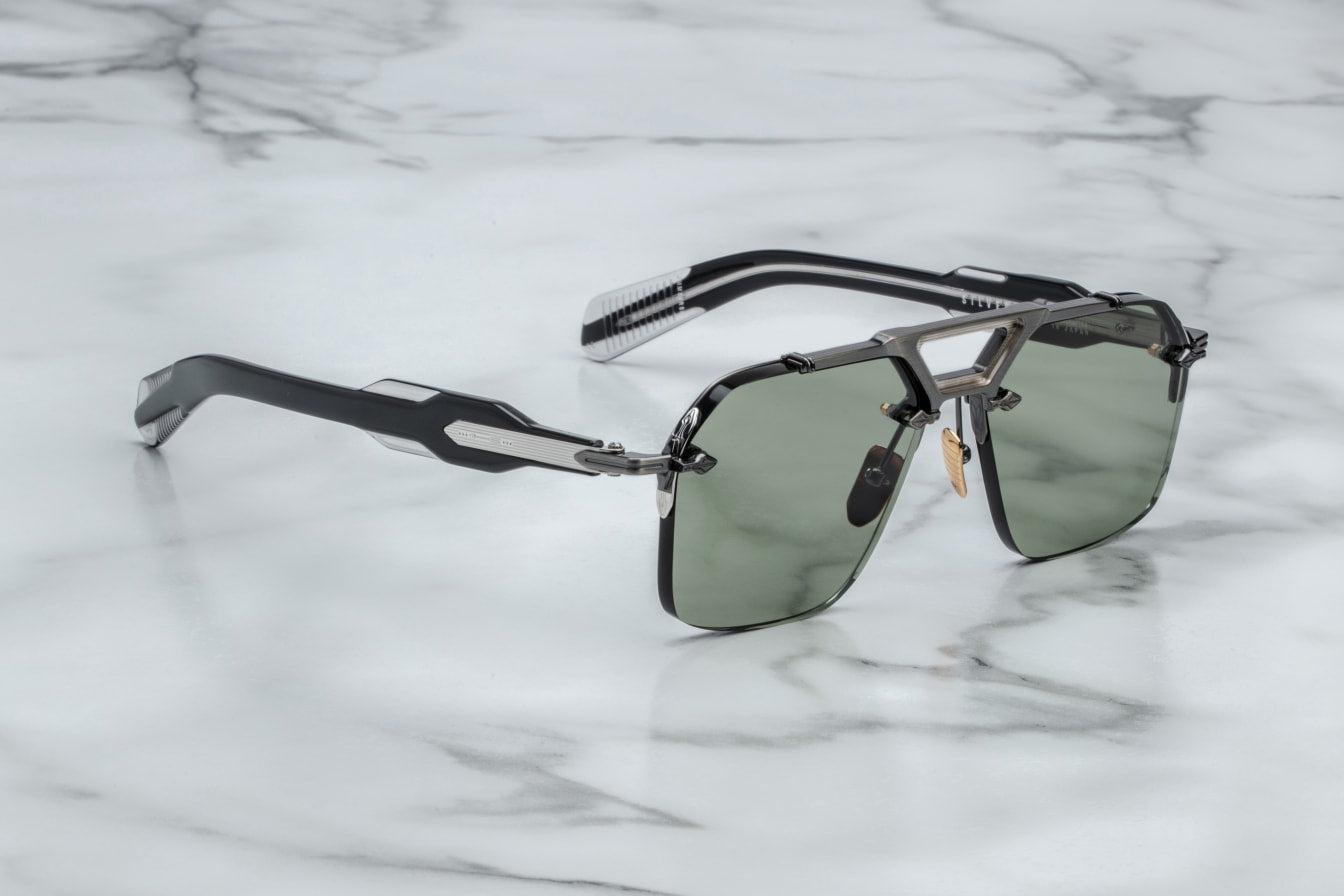 A pair of rimless sunglasses with a gunmetal frame, titanium nose-and-brow bridge, dual-tone details, sculptural acetate temples, and wirecore embellishments. side view