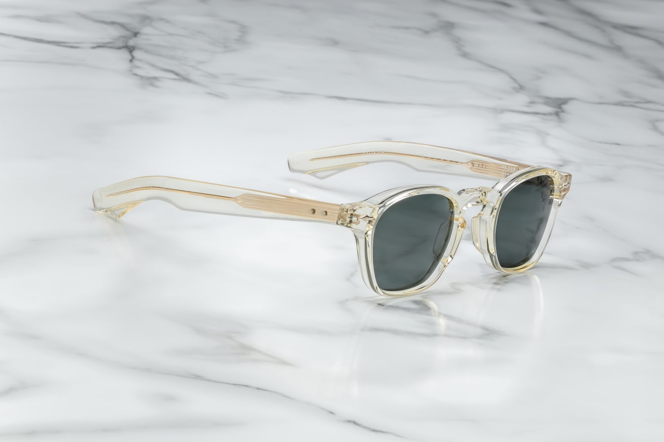 A pair of sunglasses with a distinctive frame, sculptural temples, and a sophisticated silhouette. The frame is notable for its slim lines in champgne side on view