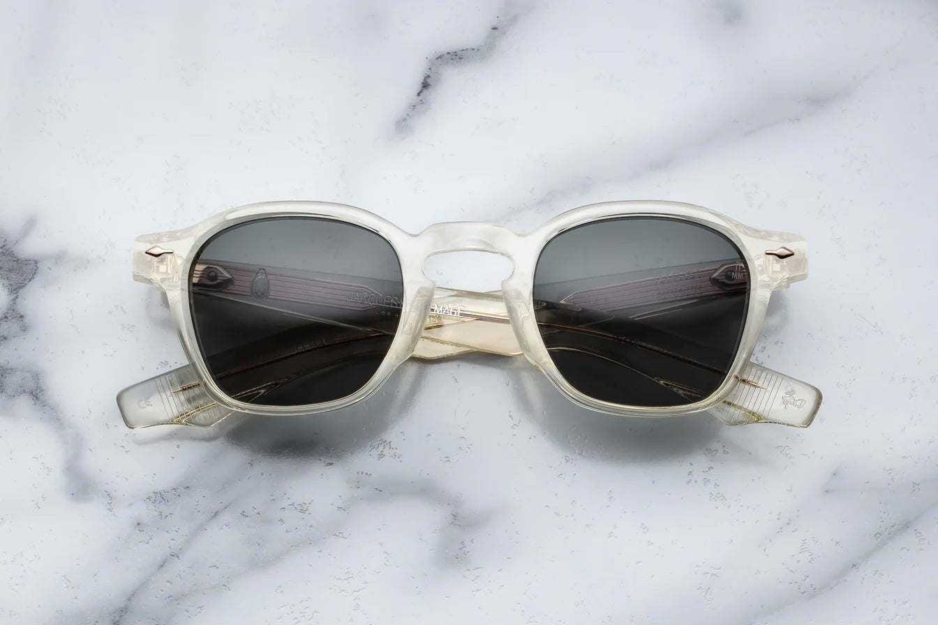 A pair of sunglasses with a distinctive frame, sculptural temples, and a sophisticated silhouette. The frame is notable for its slim lines in champgne 