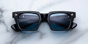 black sunglass front on with silver hammer detail on the corners and blue lenses