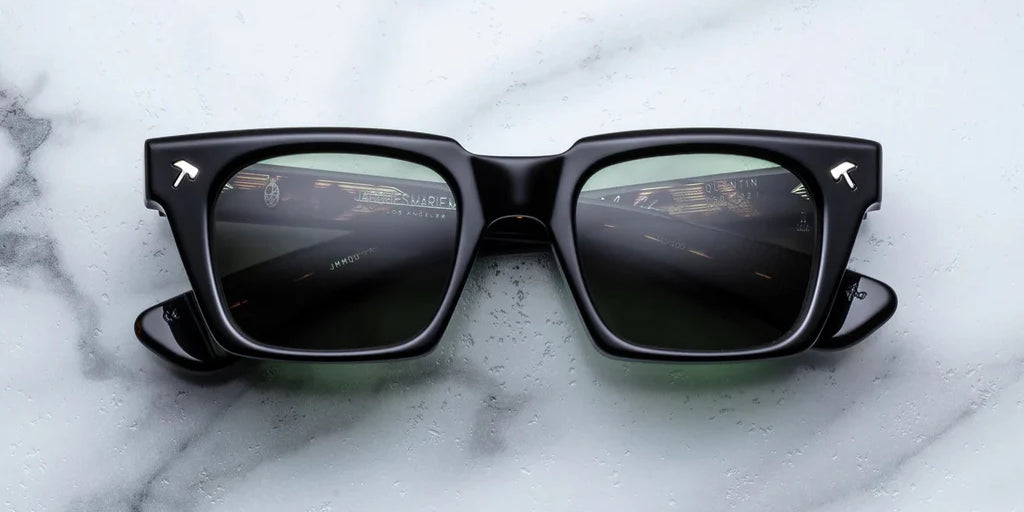 black sunglass front on with silver hammer detail on the corners and blue lenses