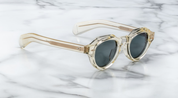 A pair of jacques marie mage frames with panto shape side on vie of the kellerman in a transparent champagne colour