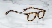 A pair of Jacques Marie Mage eyeglasses with a strong rectangular lens shape, titanium hinges, and wirecore temples with engraved details, in a Havana style pattern. side view