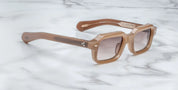 A pair of rectaunglar-shaped sunglasses with a brown frame, displayed on a marble surface. side view
